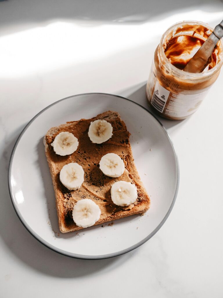 Freshly baked 4-ingredient banana bread on a wooden board with slices cut, showing its moist texture